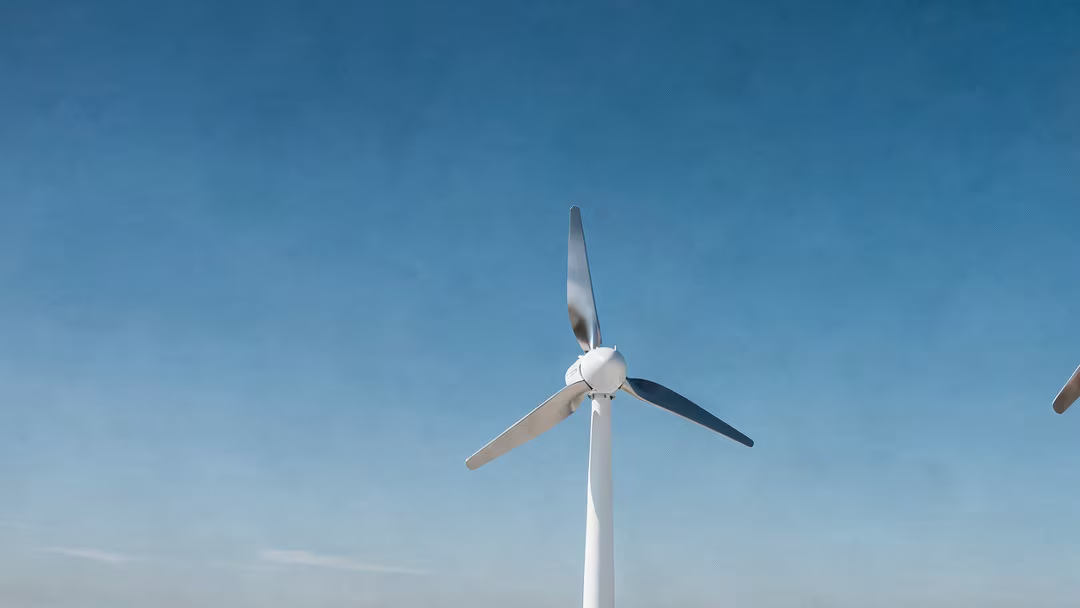 Kleinwindanlage auf einem Flachdach vor blauem Himmel